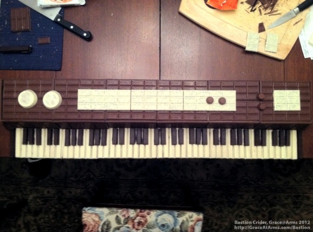 A model of an old-style electric piano made out of white and dark chocolate KitKat Bars, milk chocolate Hershey Bars, Hershey's Cookies 'n' Cream Bars, Reese's Cup Minis, and white chocolate Reese's Peanut Butter Cups, arranged and photographed by Bastion Crider of Grace at Arms (GRACE@ARMS) in February 2012.